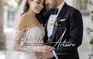 elegante diseño de texto en oro y blanco que dice: 'NUESTRA BODA' en fuente serif y los nombres de los novios 'Janette & Arturo' en caligrafía prominente, con barras ornamentales y un flourish inferior dorado. La imagen captura la textura del vestido de novia de encaje y el boutonnière del novio con eucalipto, sirviendo como la portada de una invitación web de boda original y diferente de #TeInvitare.